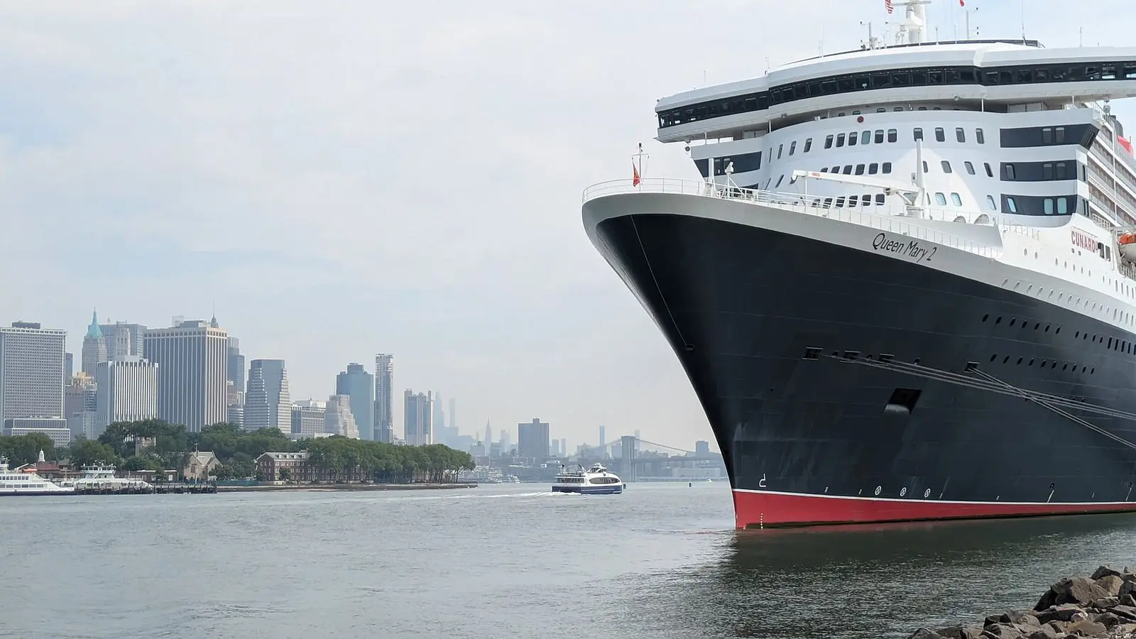 Queen Mary 2 berthed at the Brooklyn Cruise Terminal in Red Hook, with the Lower Manhattan skyline across the water